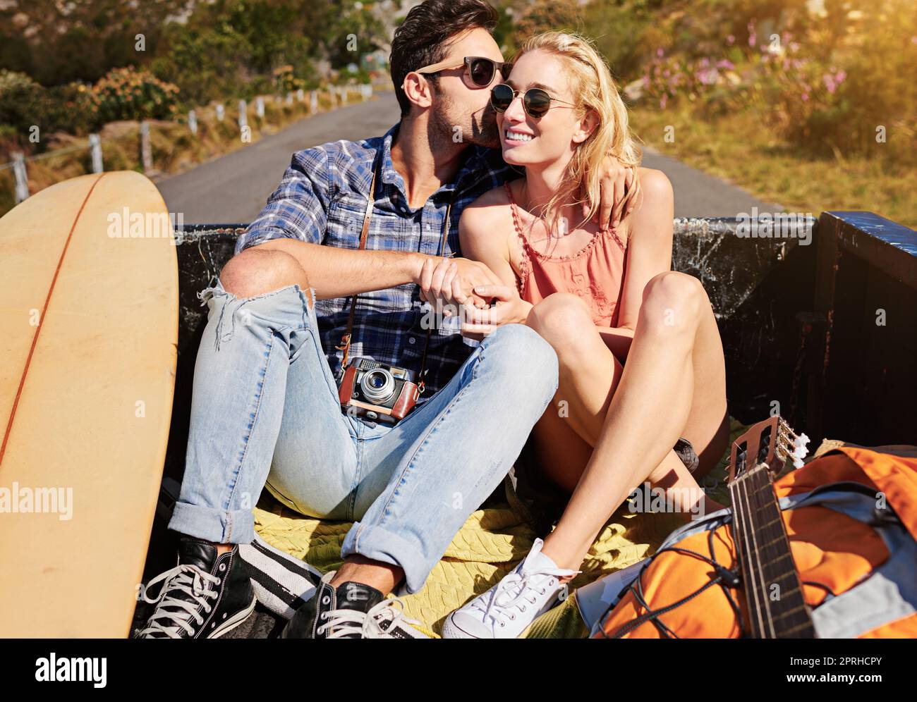 Die größten Geschichten bilden sich auf der offenen Straße. Ein junges Paar, das sich auf einer Autoreise auf dem Rücken eines Pickup-Trucks entspannt. Stockfoto