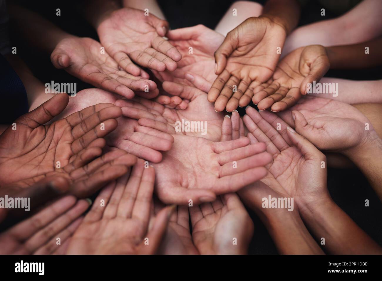 Hilf uns bitte. Eine vielfältige Gruppe von Menschen hält ihre kupierten Hände aus. Stockfoto