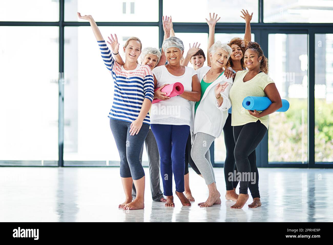 Freunde machen Spaß an der Fitness. Eine Gruppe von Frauen wartet darauf, dass der Yoga-Kurs beginnt. Stockfoto