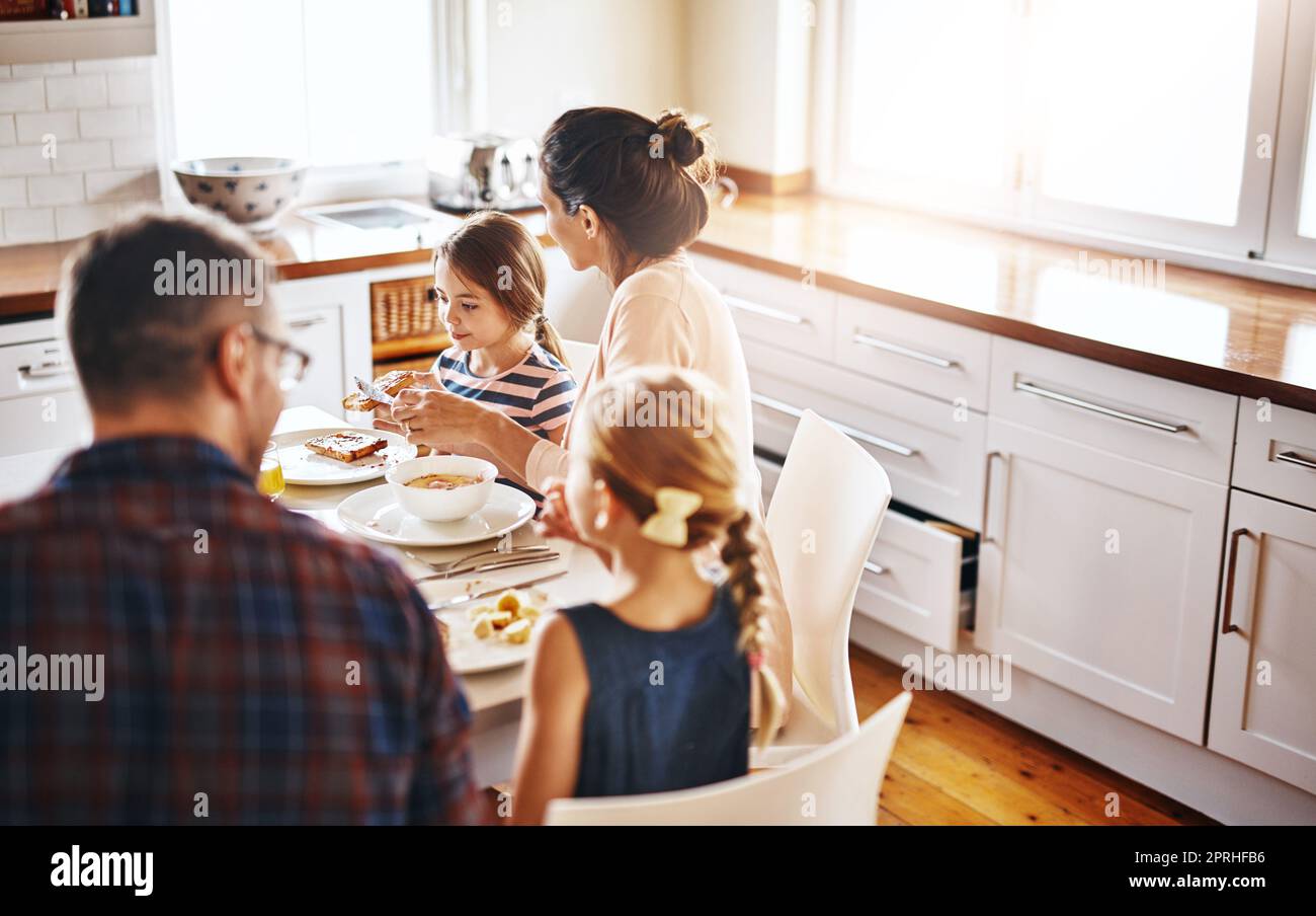 Wir alle mögen verschiedene Dinge zum Frühstück. Eine Familie genießt das Frühstück zusammen. Stockfoto