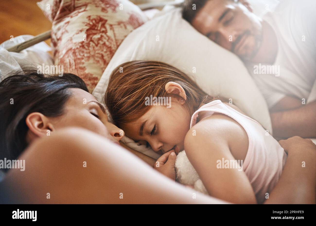 Sie wird ihr Bett nicht bald verlassen. Eine Familie schläft zu Hause im Bett. Stockfoto