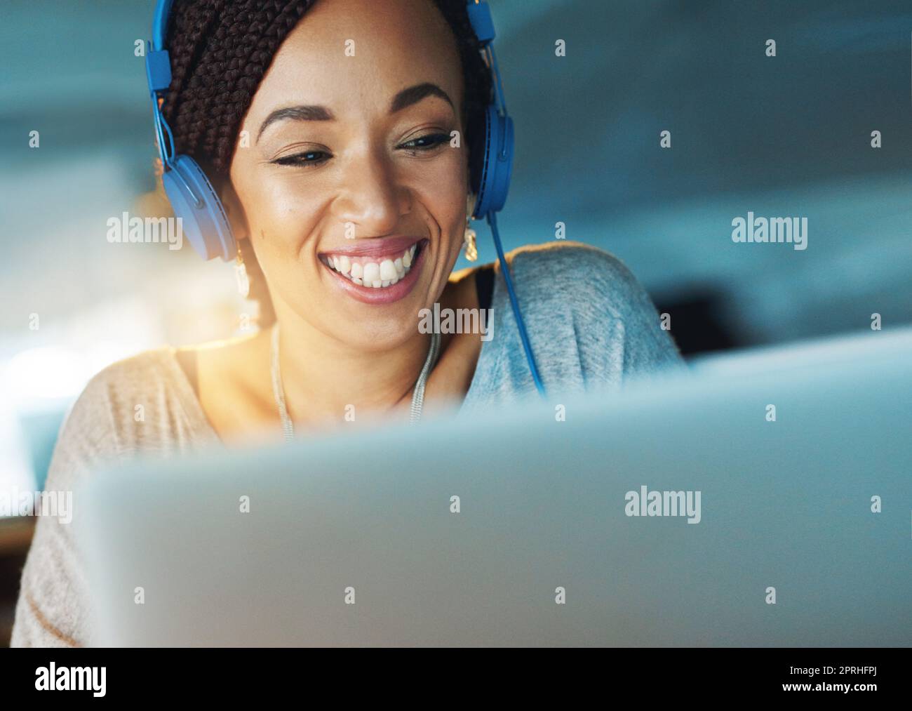 Motiviert von der Musik. Eine junge Frau, die Musik hört, während sie spät in ihrem Büro arbeitet. Stockfoto