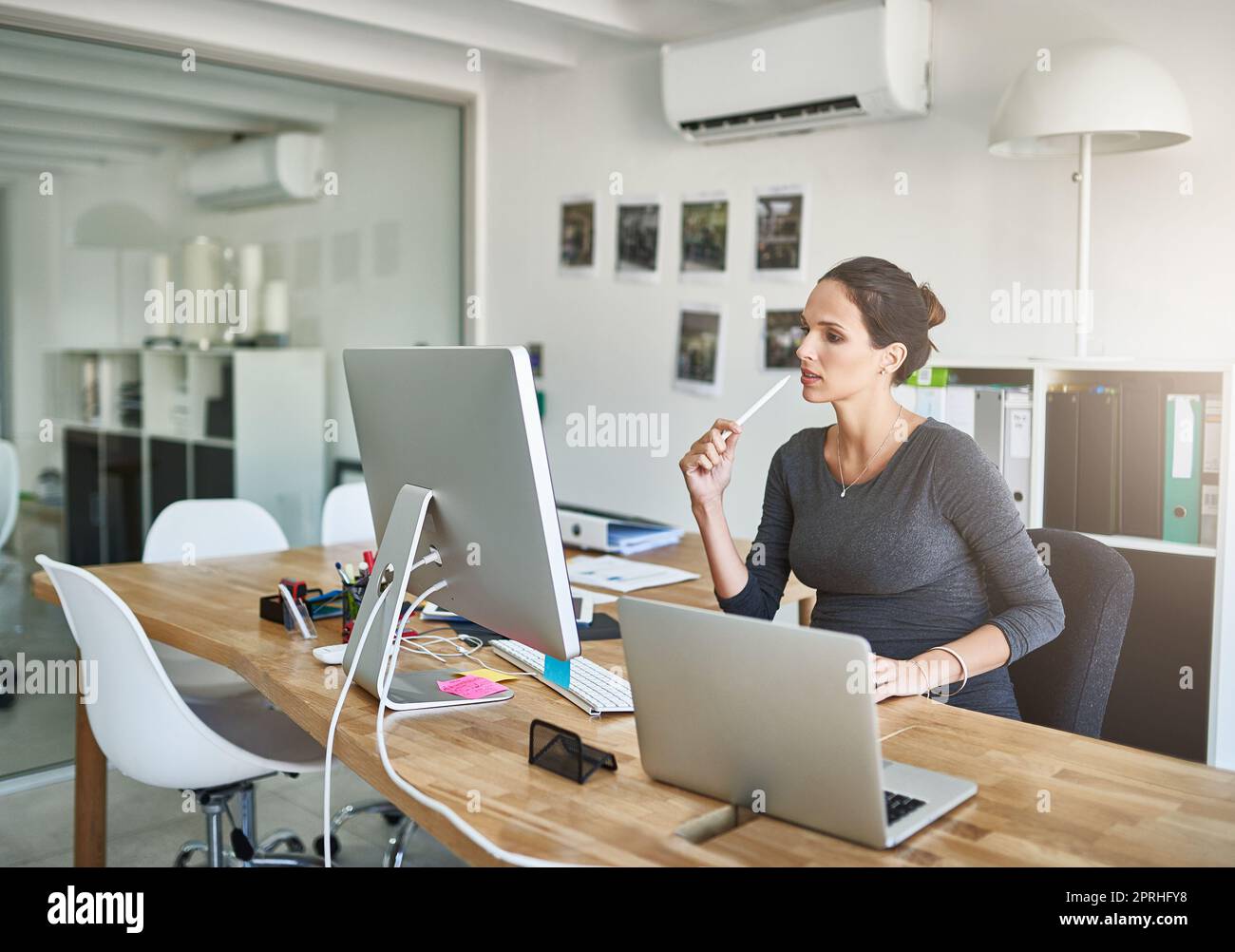 Vor ihrem Mutterschaftsurlaub einige lockere Enden einschnüren. Eine Schwangere Geschäftsfrau, die im Büro an ihrem Computer arbeitet. Stockfoto