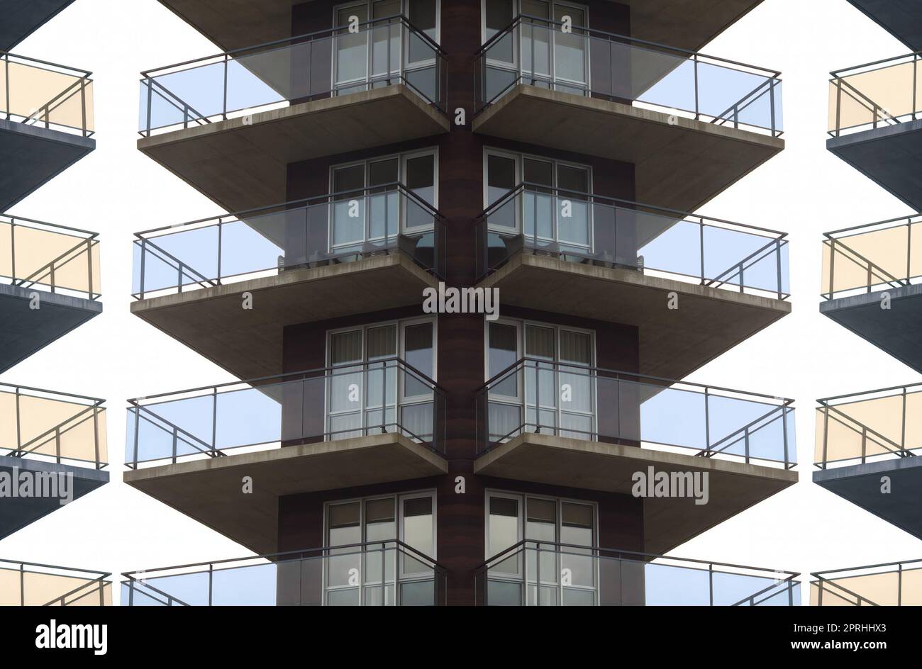 Apartmentgebäude mit Beton- und Glasbalkon, symmetrischem Spiegeleffekt, Wohnhochkratzer Stockfoto