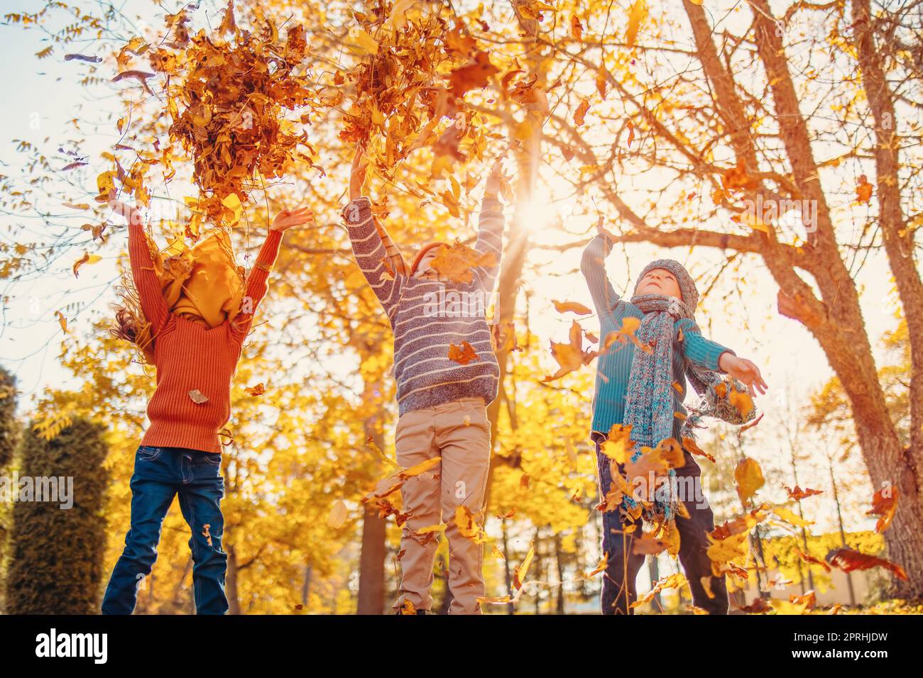 Kinder spielen am Herbsttag im farbenfrohen Naturpark zusammen Stockfoto