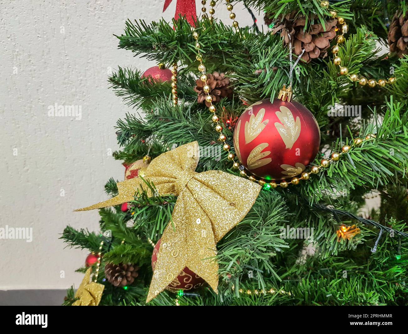 Nahaufnahme eines Weihnachtsbaums mit Schleifen, glitzernden Glaskugeln und Weihnachtsbaumspielzeug Stockfoto