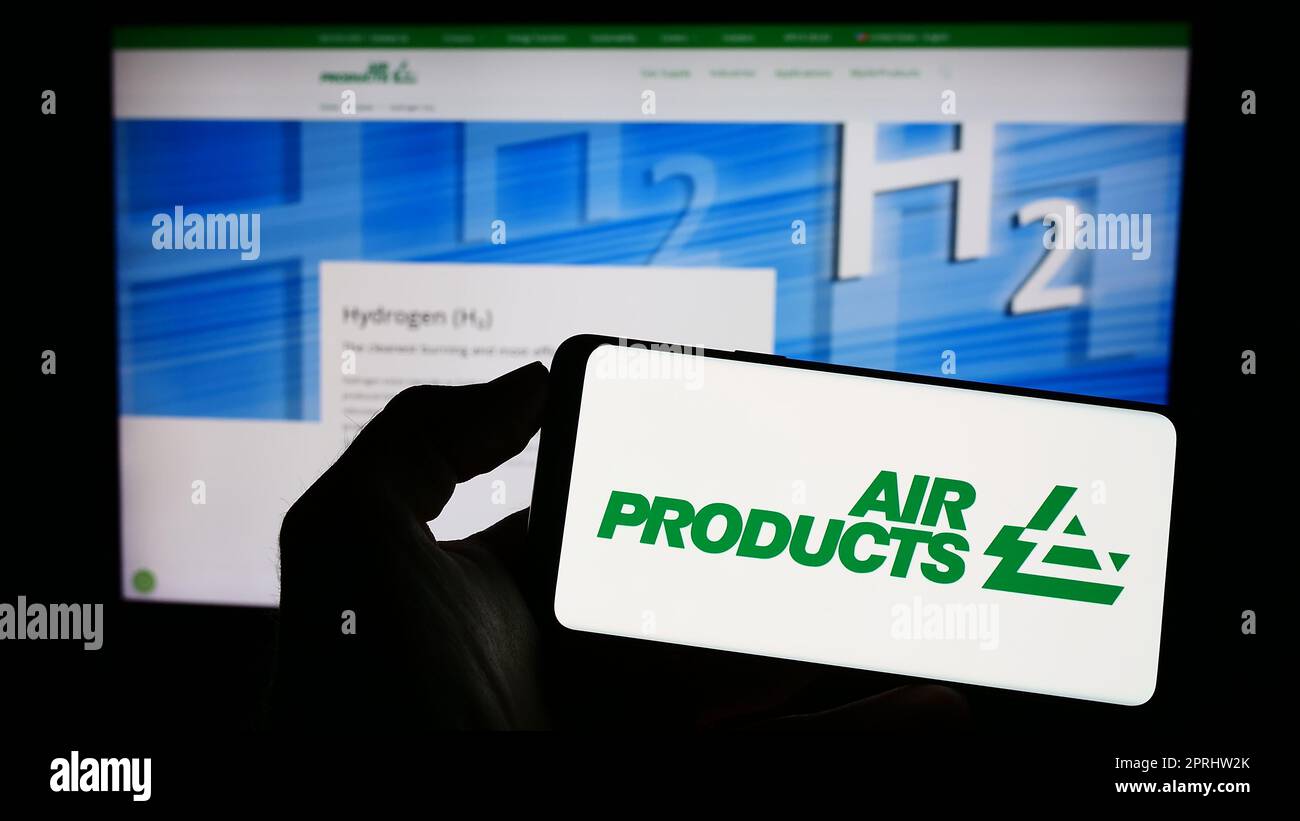 Person, die ein Mobiltelefon mit dem Logo des amerikanischen Unternehmens Air Products and Chemicals Inc. Auf dem Bildschirm vor der Webseite hält. Konzentrieren Sie sich auf das Display des Telefons. Stockfoto