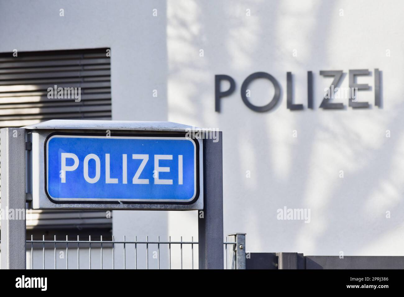 Ein blaues Schild mit der Aufschrift "Poizei" für "Polizei" auf einer deutschen Polizeiwache. Das Wort steht auch über das Gebäude. Das Bild stammt aus der Öffentlichkeit. Stockfoto