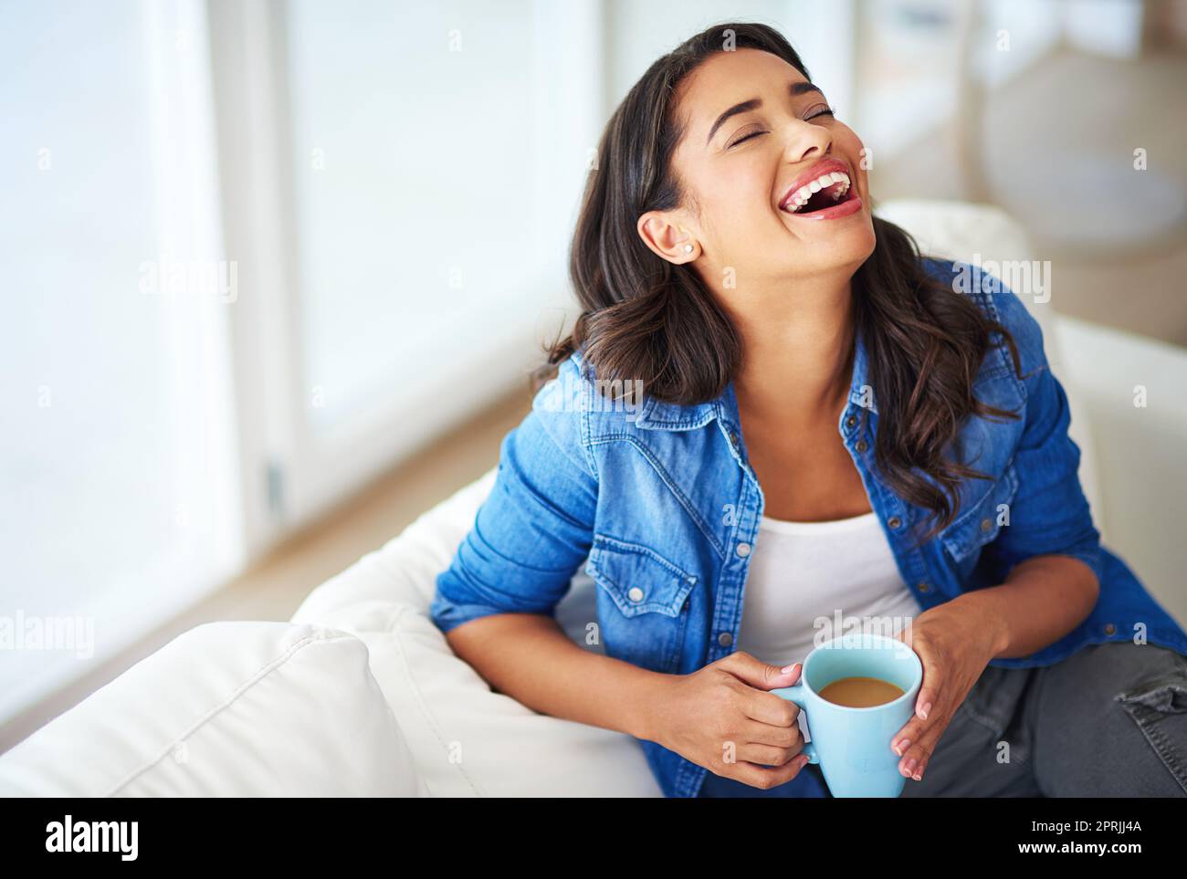 Keine Sorge in der Welt. Eine junge Frau, die Kaffee trinkt, während sie sich zu Hause entspannt. Stockfoto