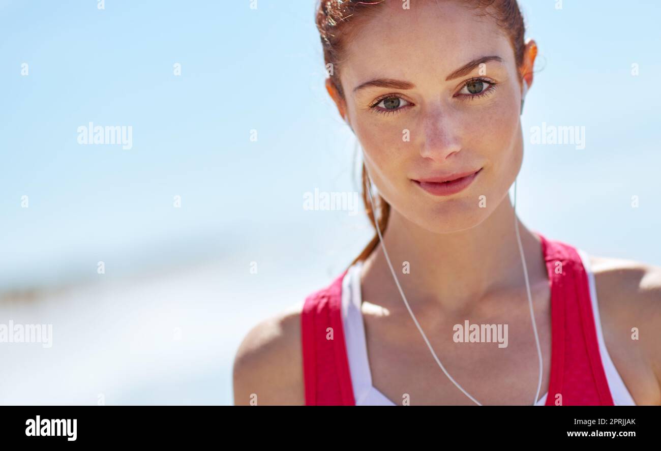 Es ist der beste Ort zum Training. Eine sportliche junge Frau am Strand. Stockfoto