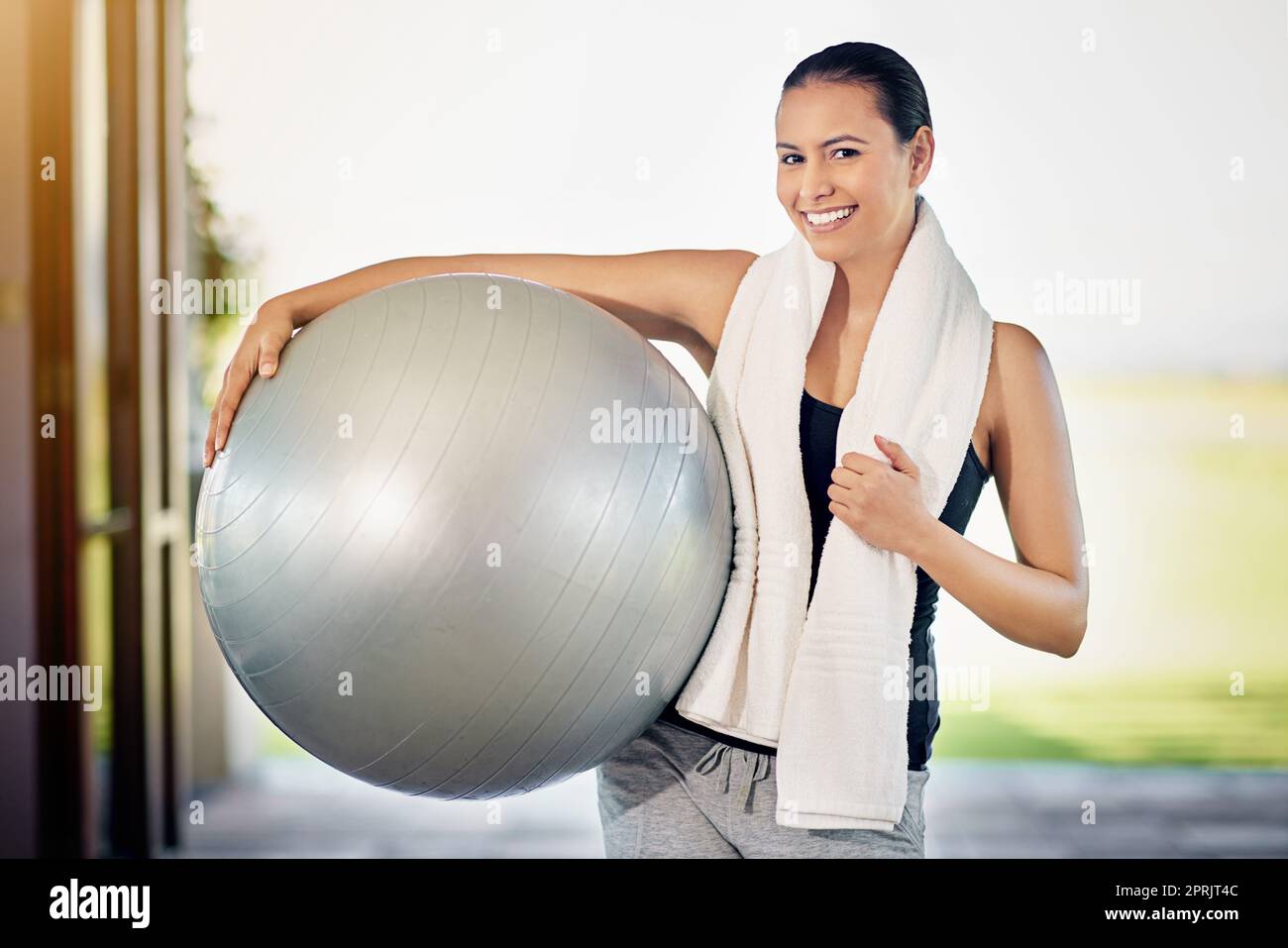 Ich bin auf einem Fitness-Buzz. Beschnittenes Porträt einer jungen Frau, die ihren Übungsball trägt. Stockfoto