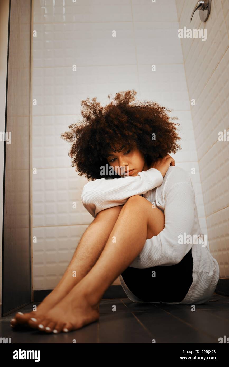 Depression, Angst und eine traurige schwarze Frau auf dem Boden, die in der Dusche oder im Badezimmer sitzt. Psychische Gesundheit, Weinen und der Stress des Lebens in der Jugend, beängstigende Gedanken für eine depressive junge Dame allein mit Angst Stockfoto