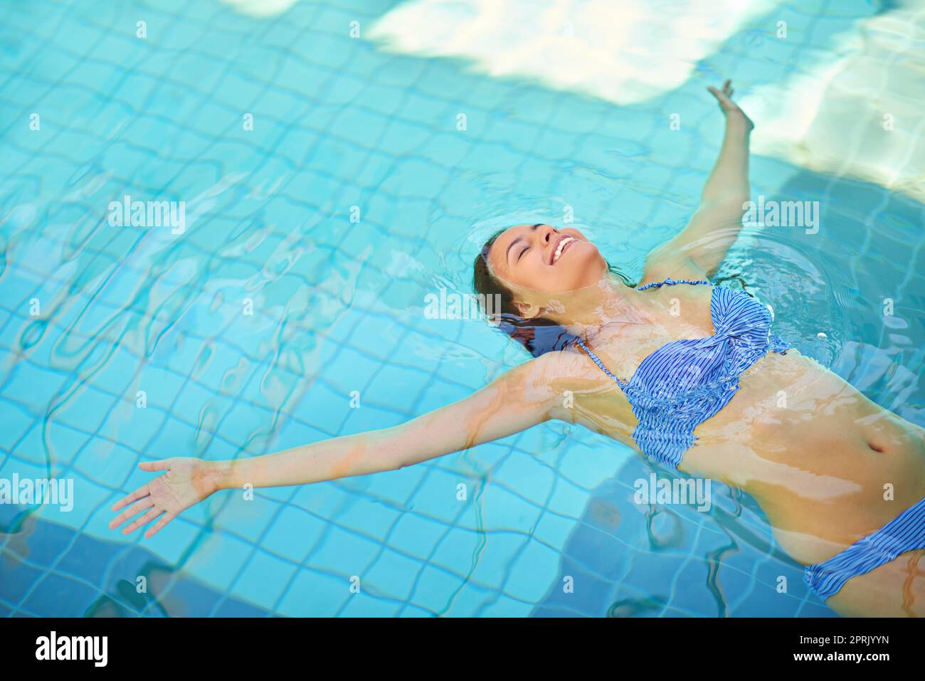 Schweben in das große Blau. Eine junge Frau, die sich im Pool in einem Spa entspannt. Stockfoto