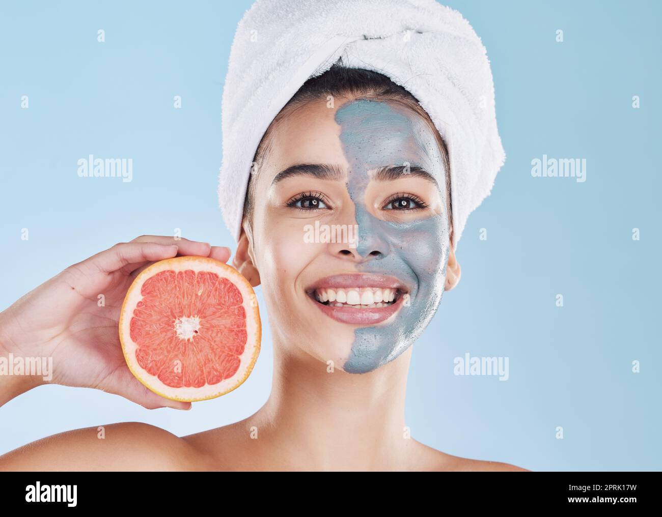 Frau, Hautpflege und Grapefruit Gesichtsmaske, organische Schönheit und Wellness für gesundes Gesicht, frisches Gesicht und natürlich saubere glühende Haut auf blauem Hintergrund. Porträt, Lächeln und Modellpflege Stockfoto