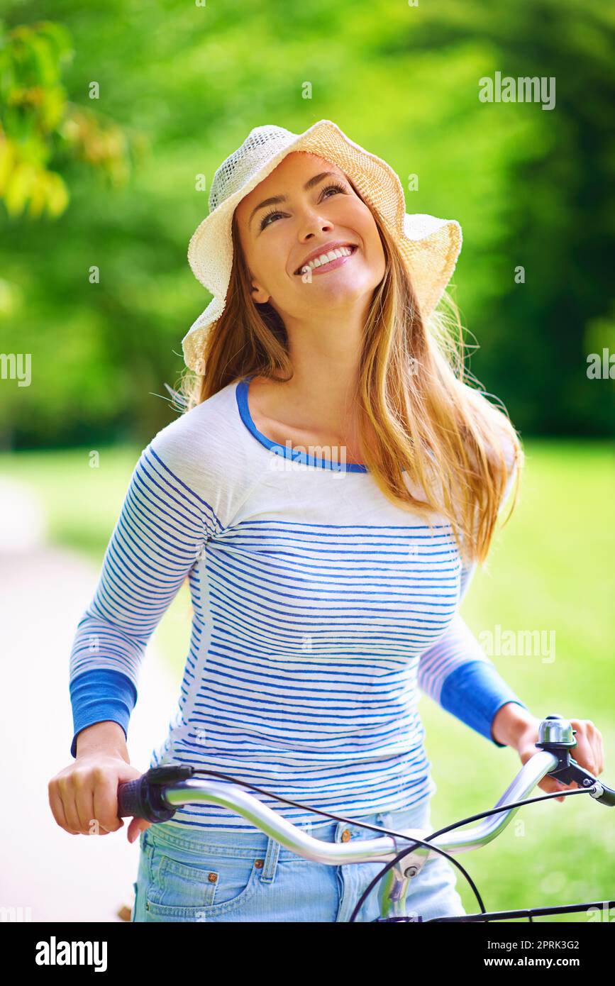 Erkunden Sie die Natur mit dem Fahrrad. Eine junge Frau, die im Park radelt. Stockfoto