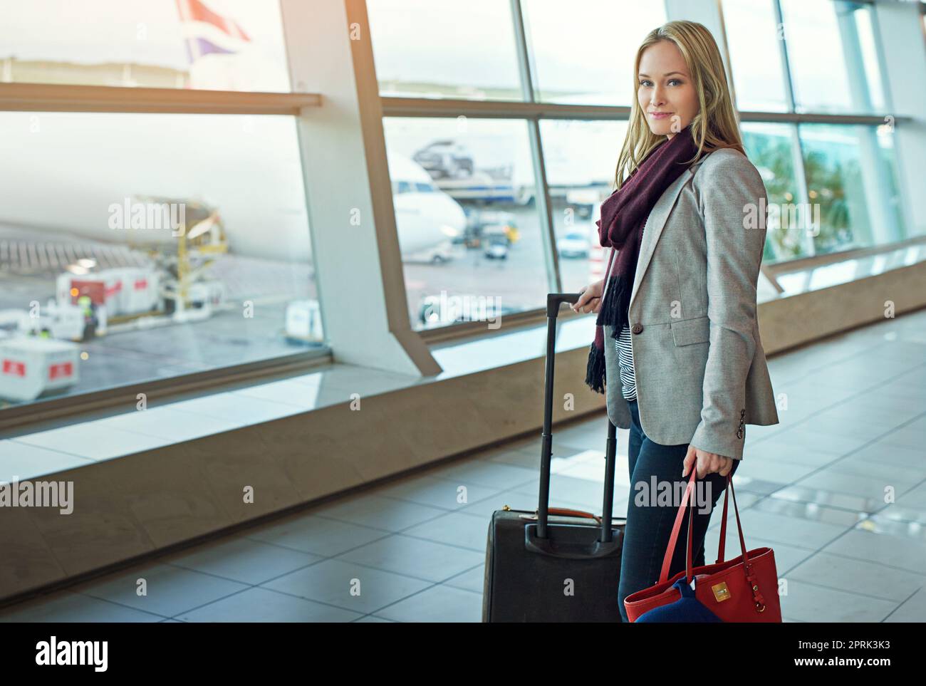 Fast Boarding-Zeit. Porträt einer jungen Frau, die mit ihrem Gepäck auf einem Flughafen steht. Stockfoto