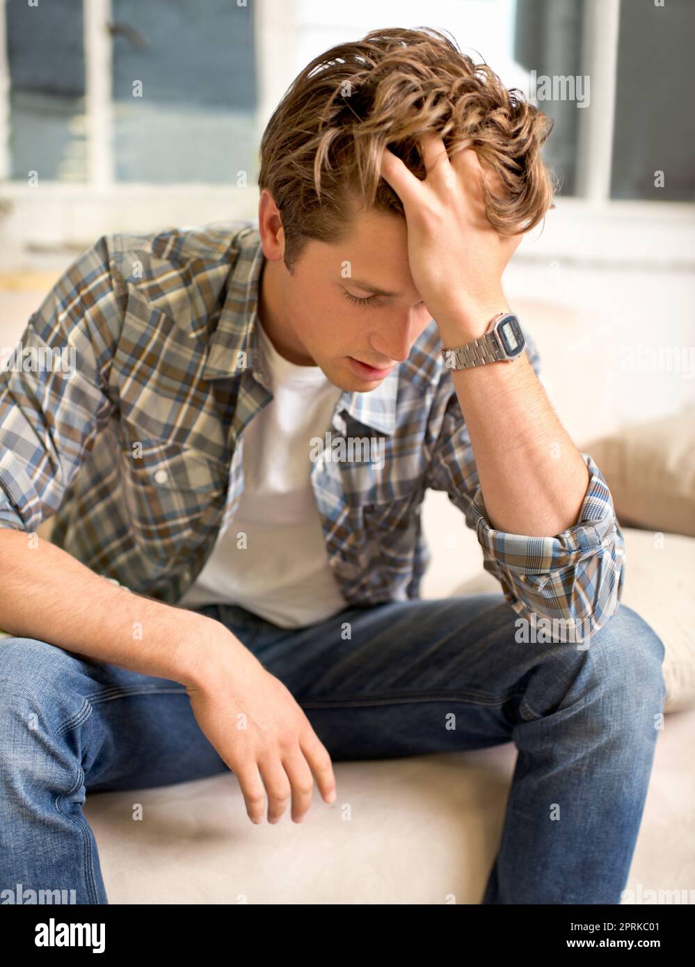 Das Leben ist so ungerecht. Ein junger Mann sitzt mit der Hand im Haar