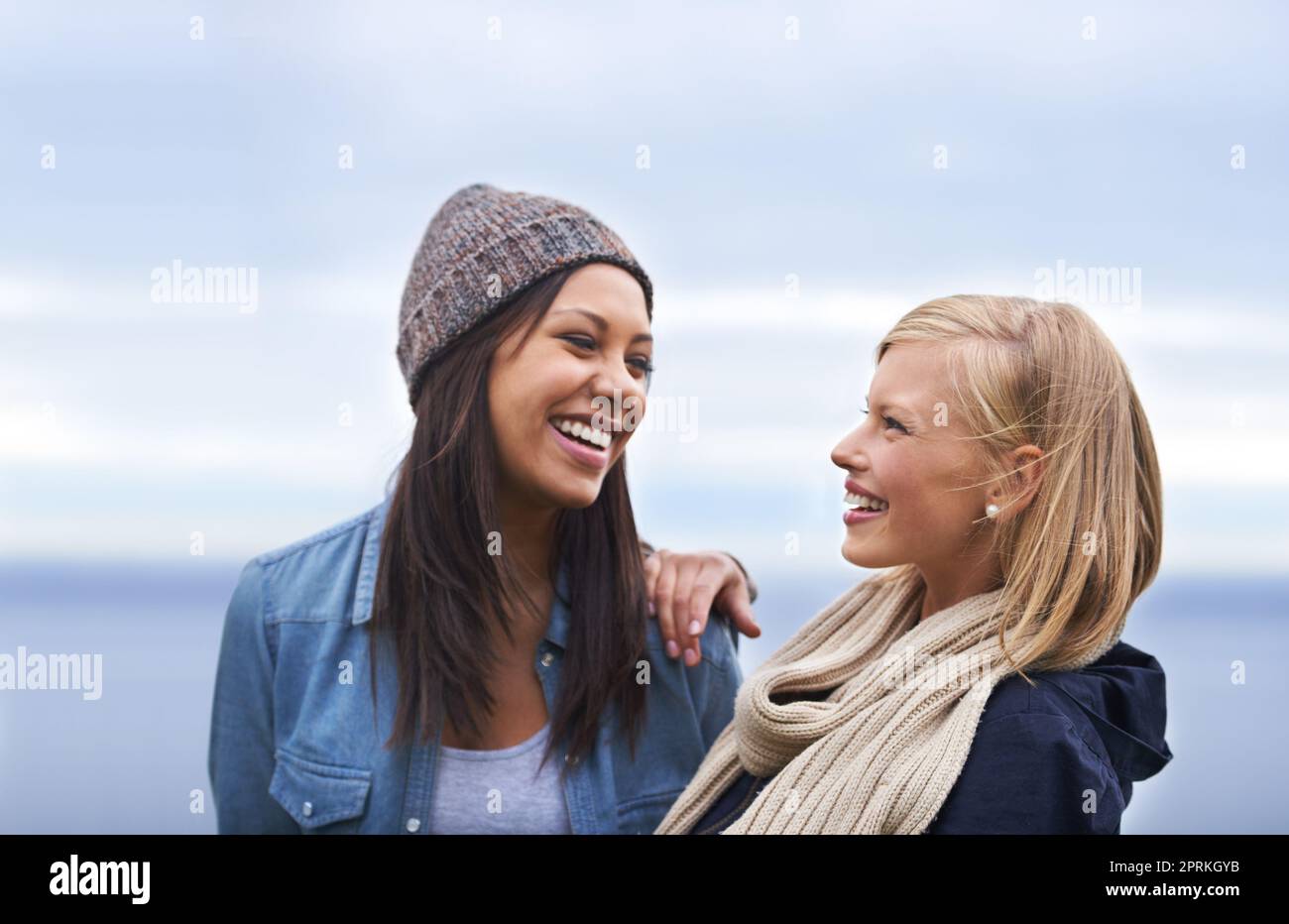 Es geht nichts über Freundschaft und Lachen. Zwei glückliche junge Frauen, die am Strand lächeln Stockfoto