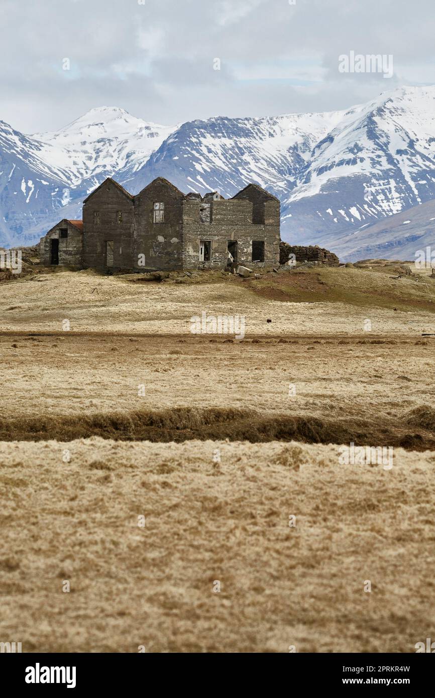 Verlassene Hausruinen in Island mit Bergen im Hintergrund Stockfoto