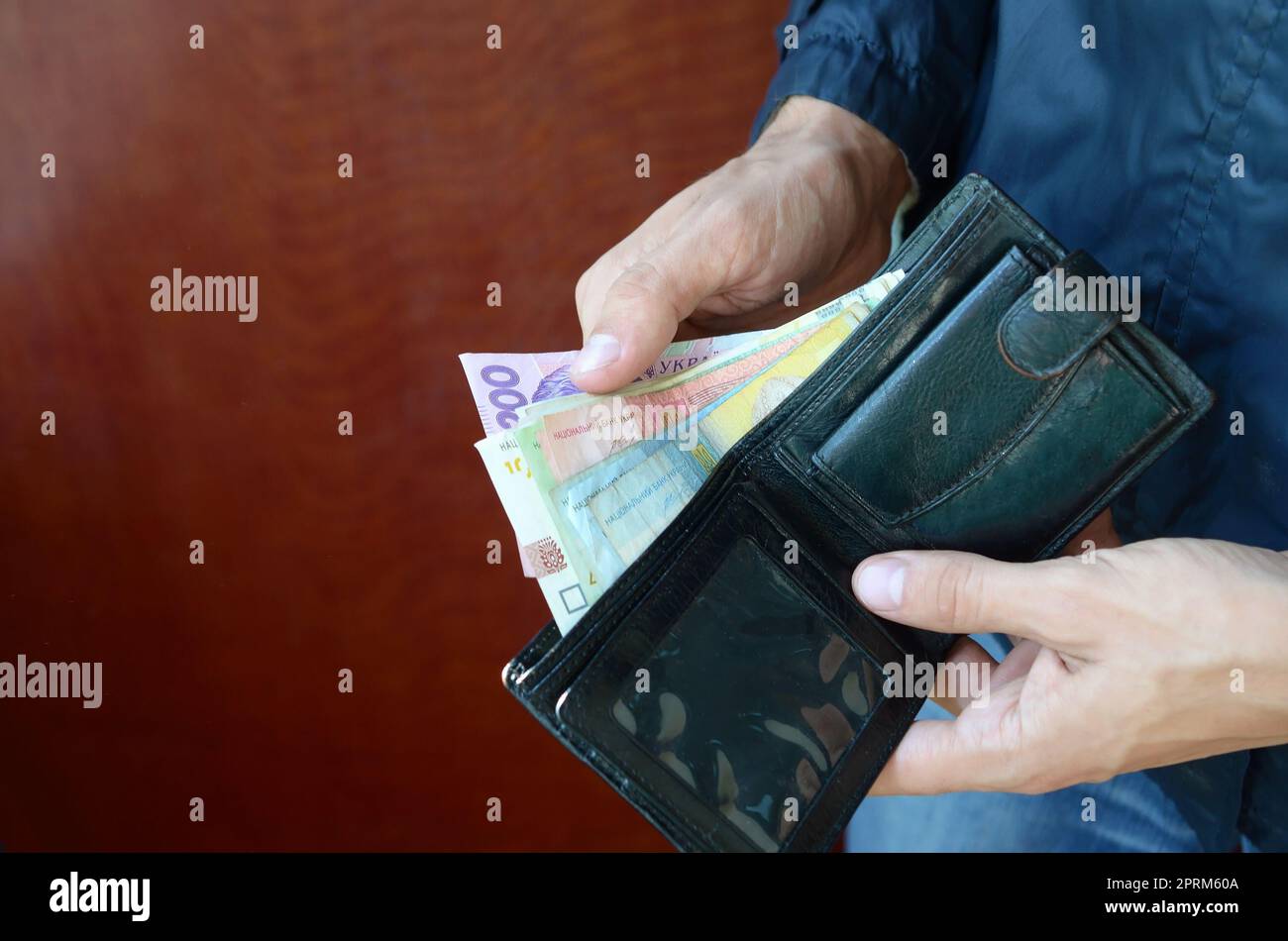Nahaufnahme der männlichen Händen öffnete die Brieftasche oder Geldbörse mit ukrainischen Geld Währung Griwna. Gehalt in der Ukraine. Große Menge Geld Stockfoto
