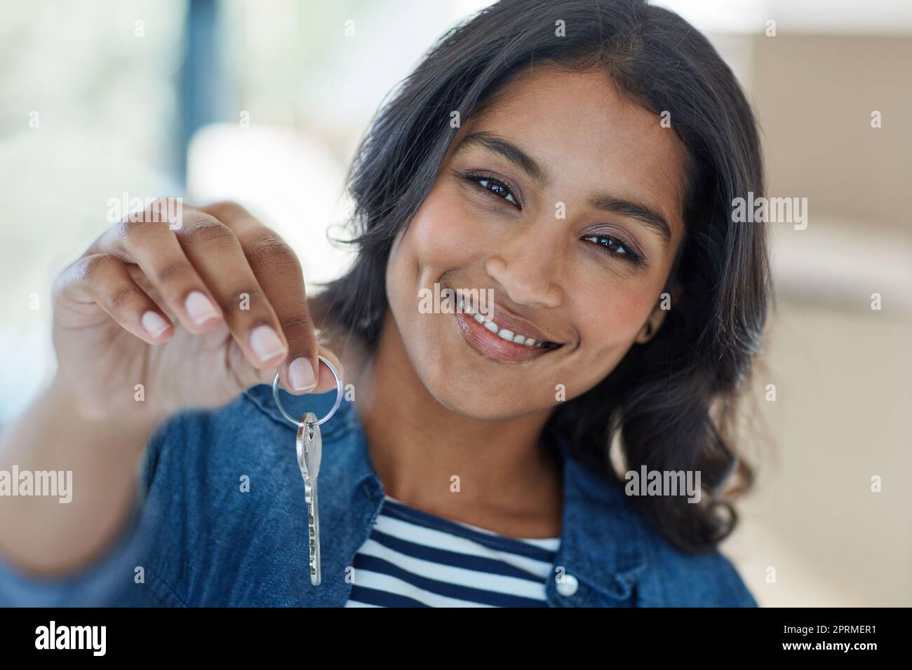 Shes der stolze neue Besitzer dieses Hauses. Porträt einer glücklichen jungen Frau, die die Schlüssel zu ihrem neuen Zuhause hochhält. Stockfoto