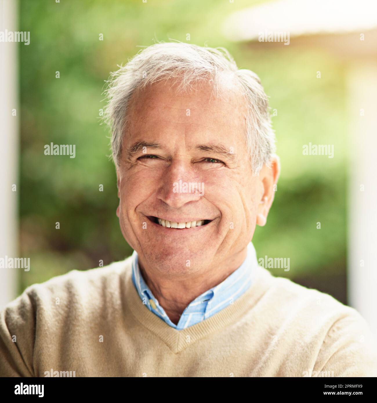 Ich habe Glück zur Gewohnheit gemacht. Porträt eines glücklichen älteren Mannes, der draußen steht. Stockfoto