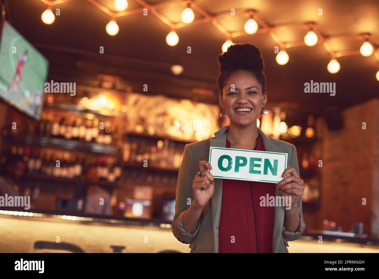 Willkommen im besten Café der Stadt. Porträt einer jungen Geschäftsbesitzerin, die ein offenes Schild in ihrem Café hält. Stockfoto
