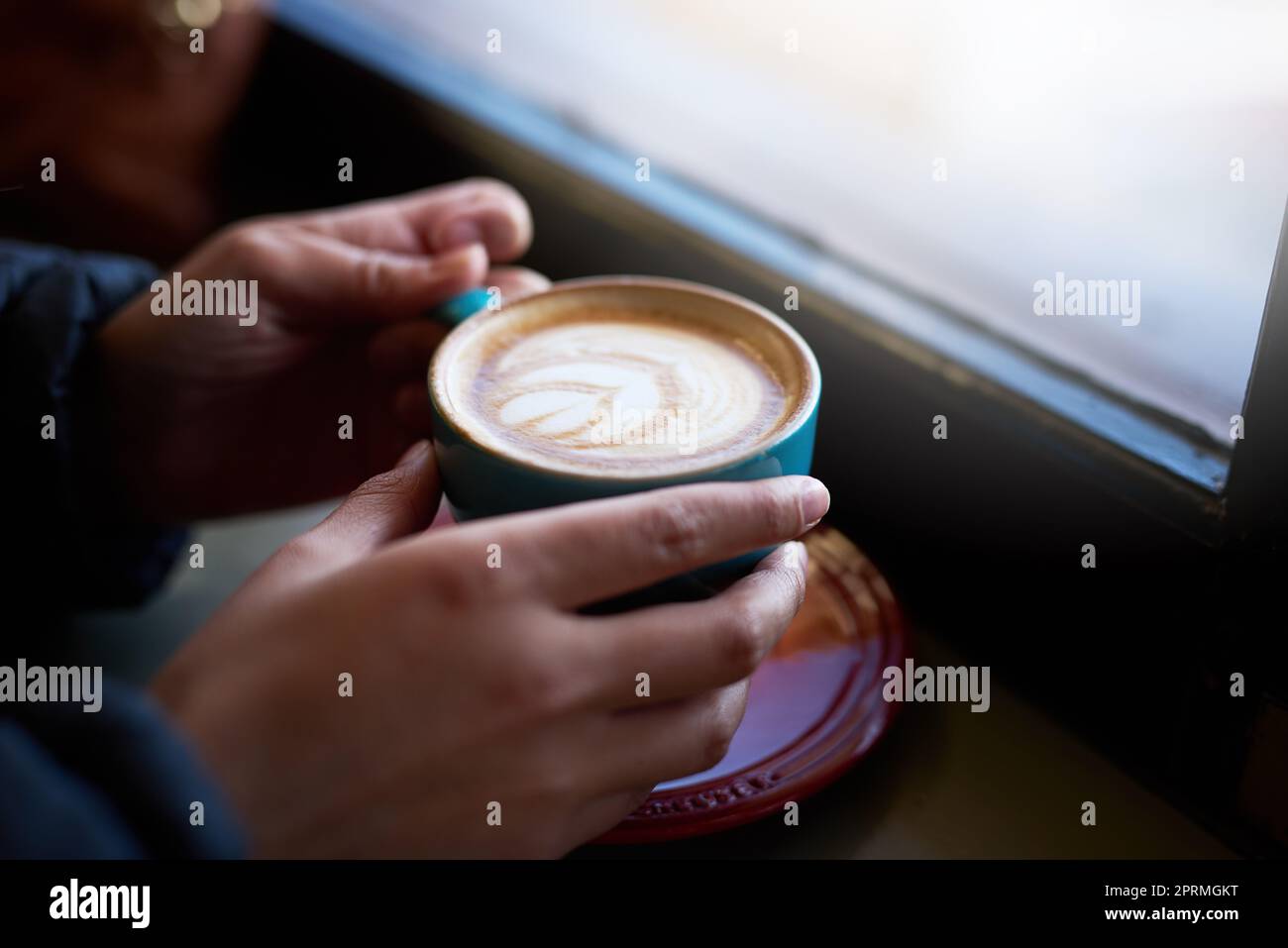 Kaffee bietet den besten Komfort. Nahaufnahme einer Frau, die in einem Café einen Cappuccino genießt. Stockfoto