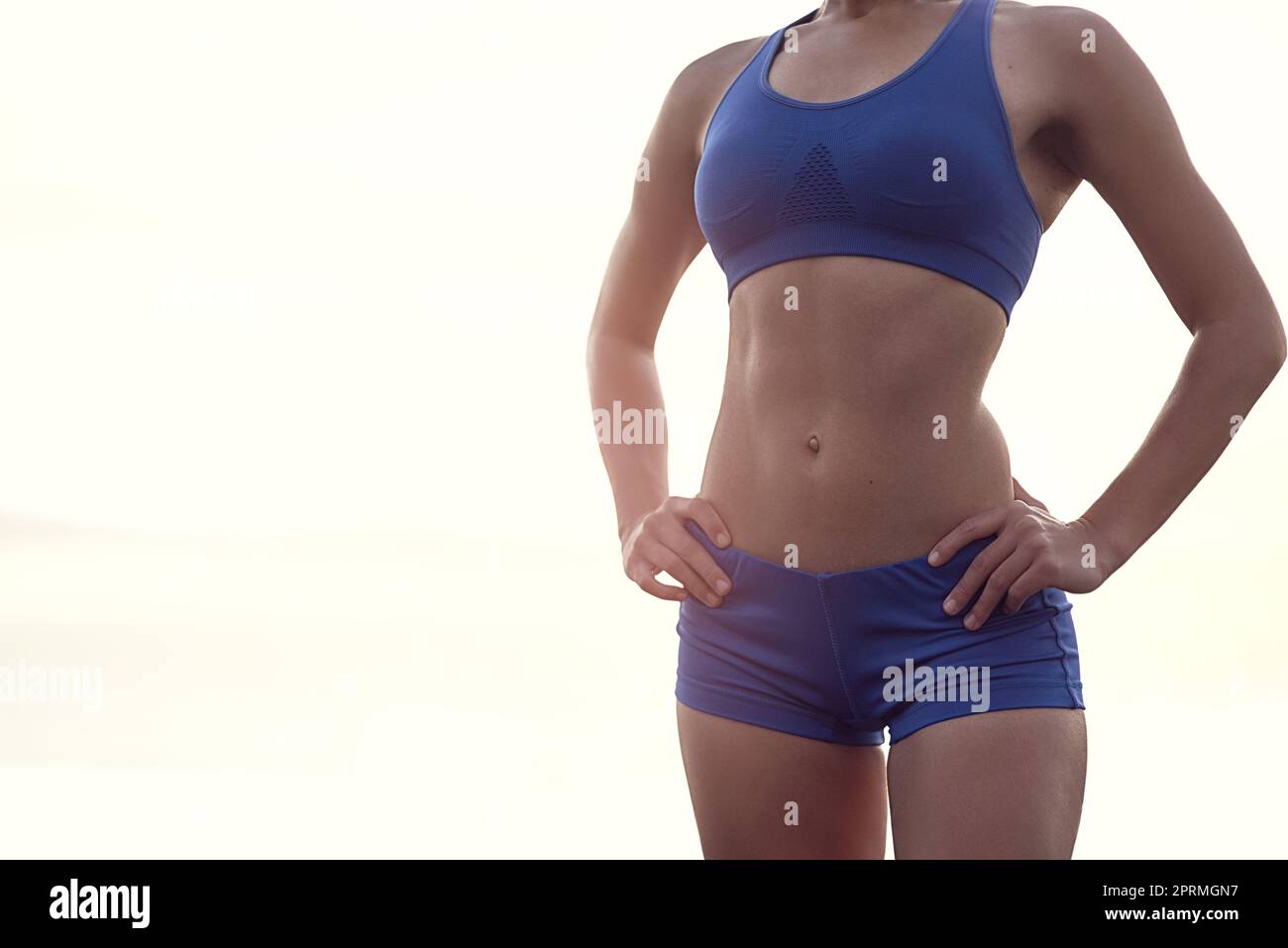 Ihr Körper ist jedes Workout wert. Eine fraute Frau in Sportbekleidung zeigt stolz ihren straffen Körper. Stockfoto