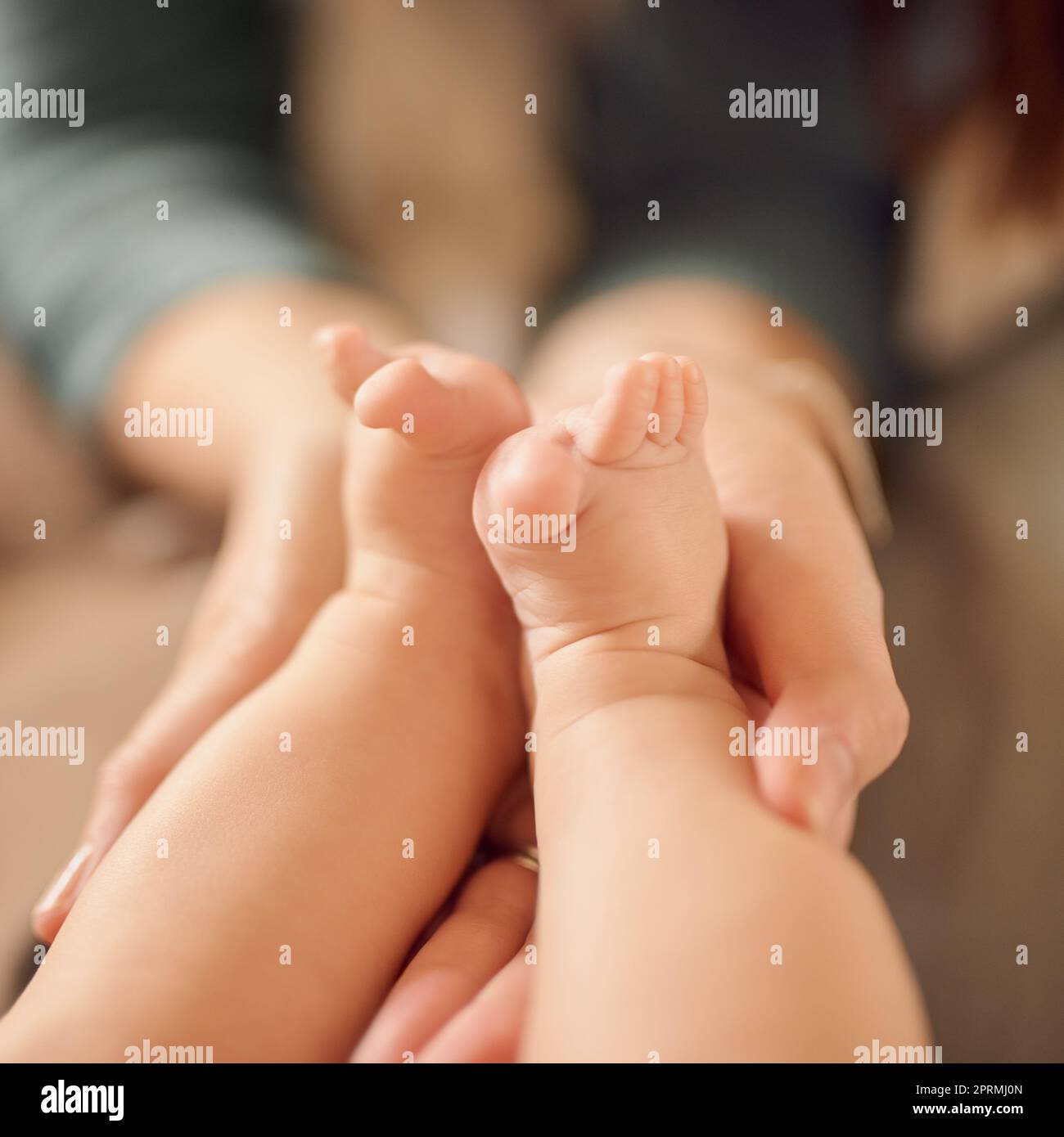 Große Geschichten beginnen mit kleinen Kapiteln. Eine nicht identifizierbare Mutter hält ihre Babys Füße. Stockfoto