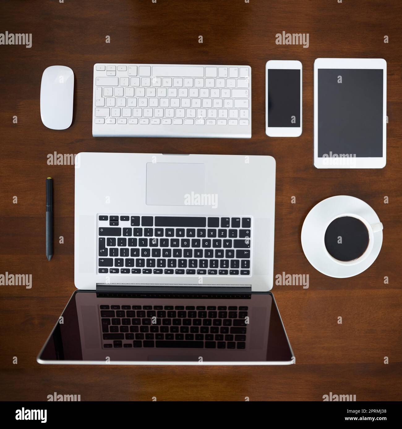Der drahtlose Arbeitsbereich. High-Angle-Aufnahme verschiedener digitaler Geräte auf einem Tisch. Stockfoto