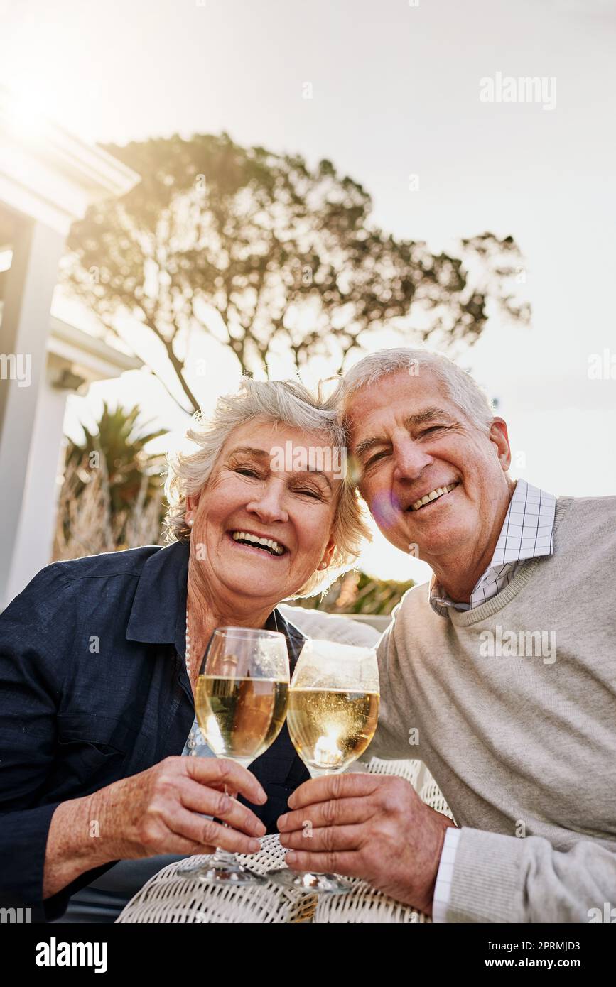 Heres zu einem glücklichen und erholsamen Ruhestand. Ein glückliches Senior-Paar mit Wein an einem gemütlichen Nachmittag draußen zu toasten. Stockfoto