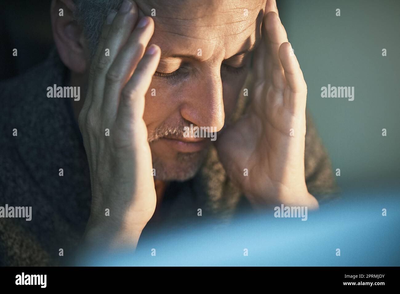 Er kann nicht viel mehr von diesen späten Nächten. Ein reifer Geschäftsmann, der gestresst aussieht, während er spät im Büro arbeitet. Stockfoto