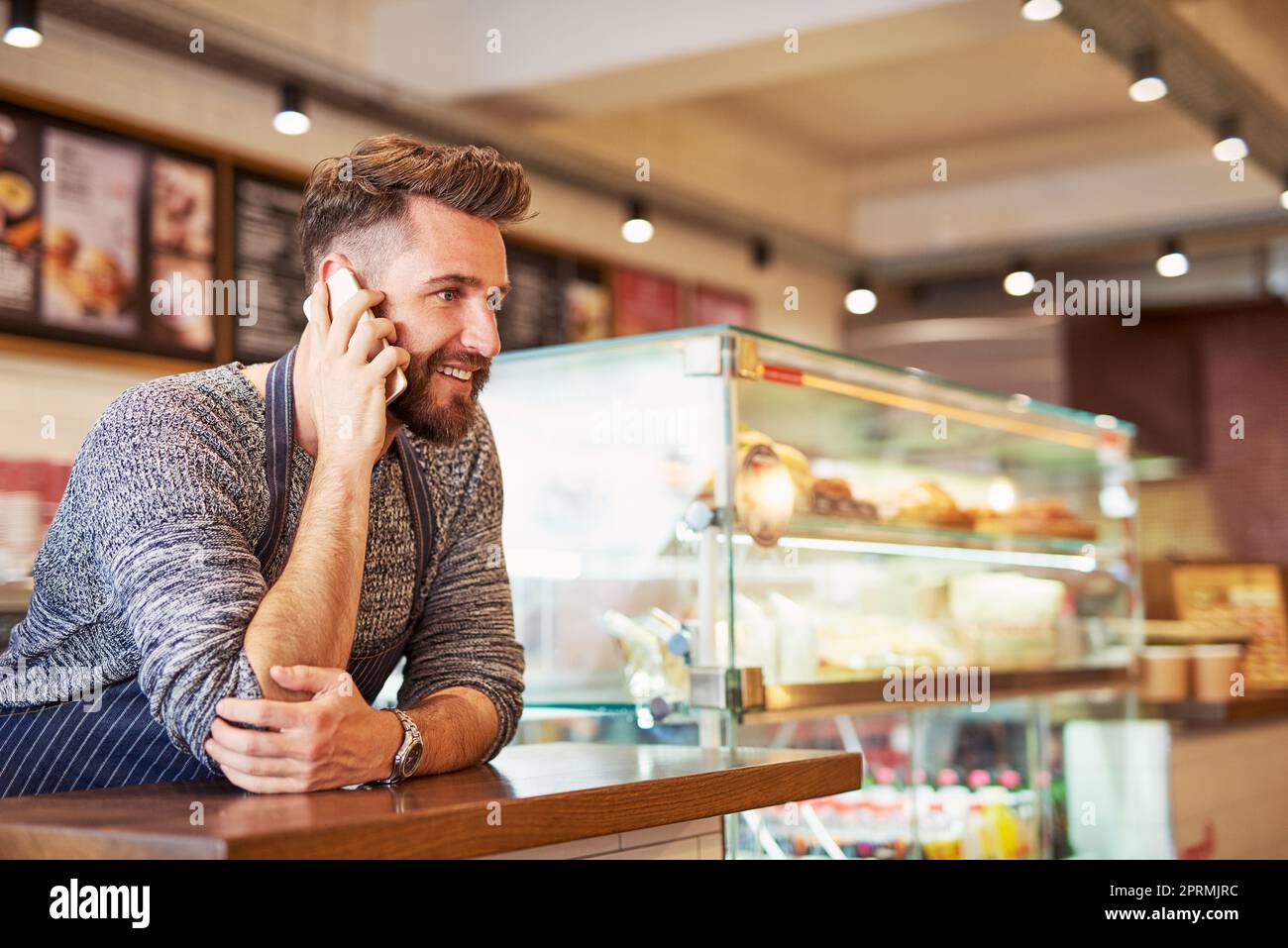 Erfolg ist sein Hauptziel. Ein Unternehmer, der in seinem Café auf einem Handy spricht. Stockfoto