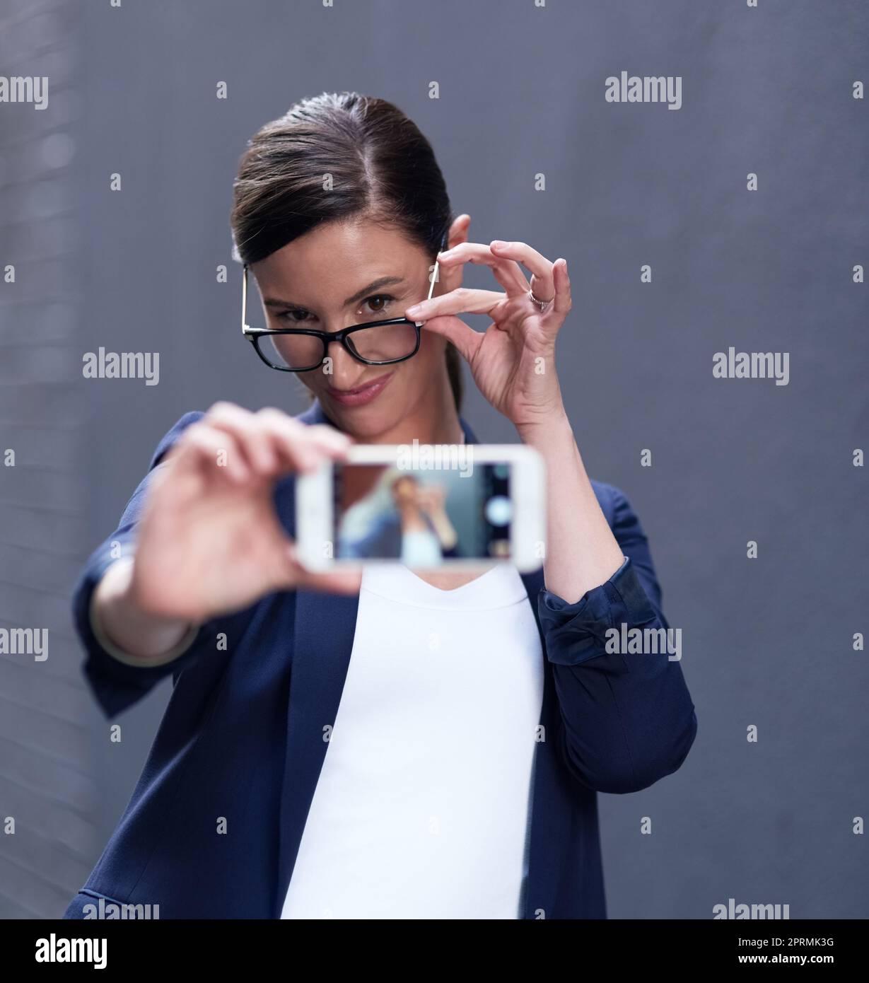 Es gibt immer Zeit für ein Selfie. Eine glückliche Geschäftsfrau nimmt ein lustiges Selfie mit ihrem Smartphone. Stockfoto