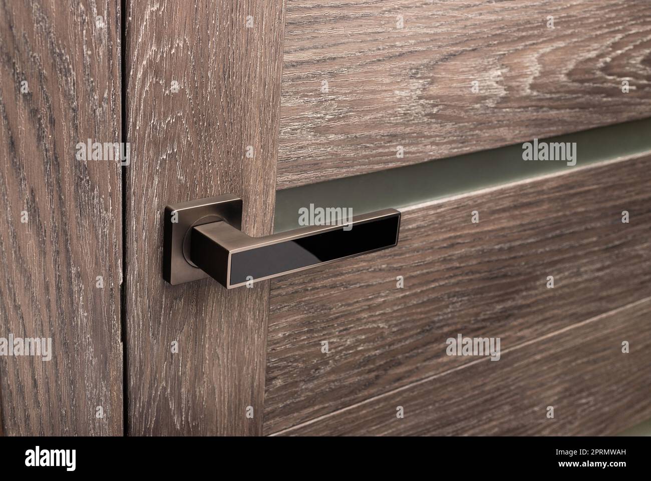 Braune Holztür mit Betonung auf Metallgriff. Stockfoto