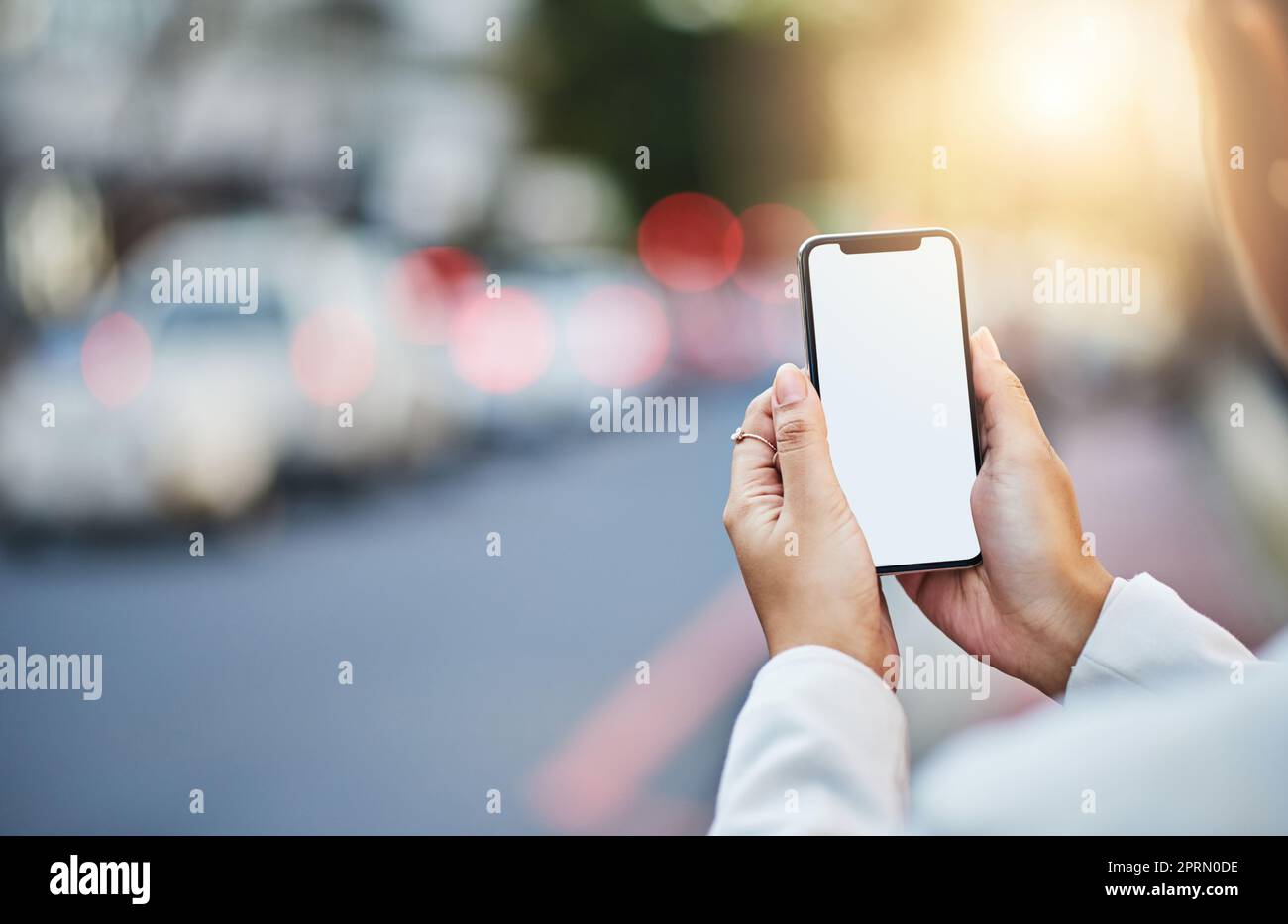 Die beste WLAN-Verbindung finden. Nahaufnahme einer unbekannten Geschäftsfrau, die ein Handy mit leerem Bildschirm in der Stadt benutzt Stockfoto