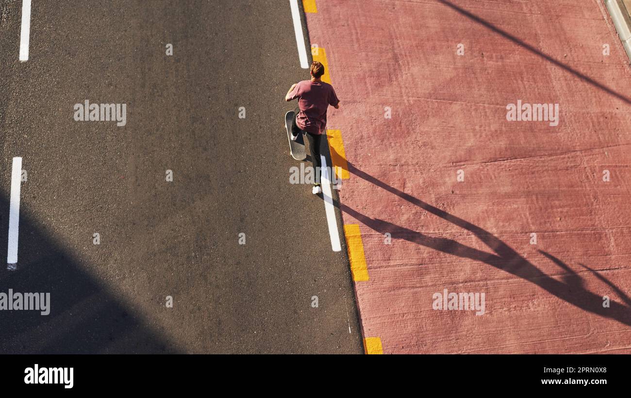 Es ist Zeit, auf der Betonwelle zu reiten. Ein junger Mann, der in der Stadt Schlittschuh fährt. Stockfoto