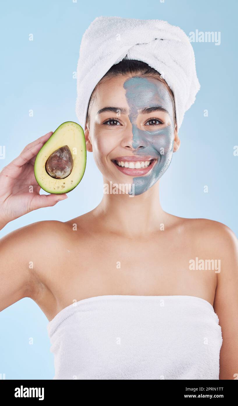 Avocado Gesichtsmaske für Beauty Hautpflege, Lebensmittel für die Gesundheit der Haut und Produkt für Ernährung Diät vor blauem Mockup Studio Hintergrund. Portrait eines glücklichen, gesunden und brasilianischen Mädchens mit kosmetischen Früchten Stockfoto