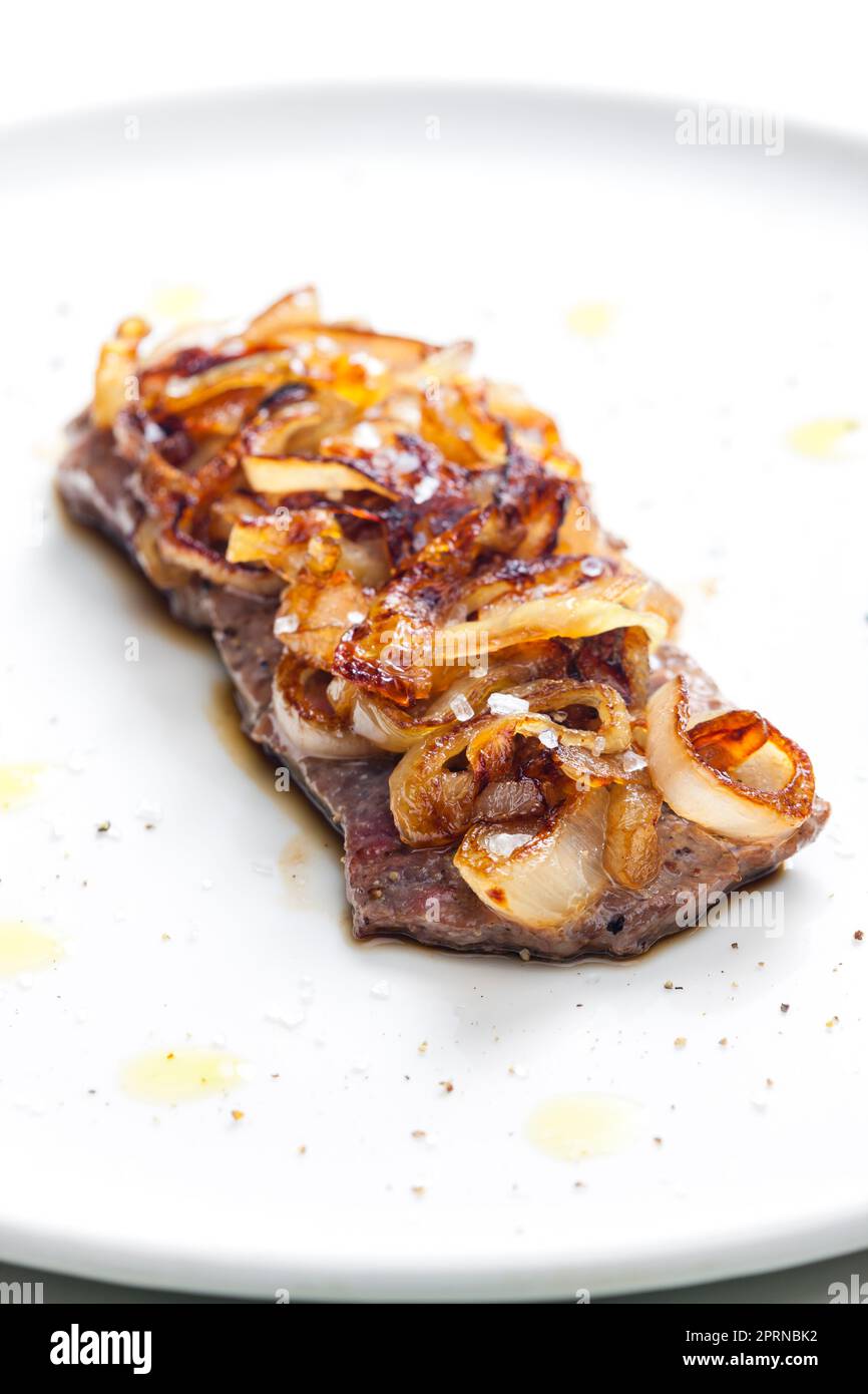 Steak mit karamellisierten Zwiebeln bedeckt Stockfoto