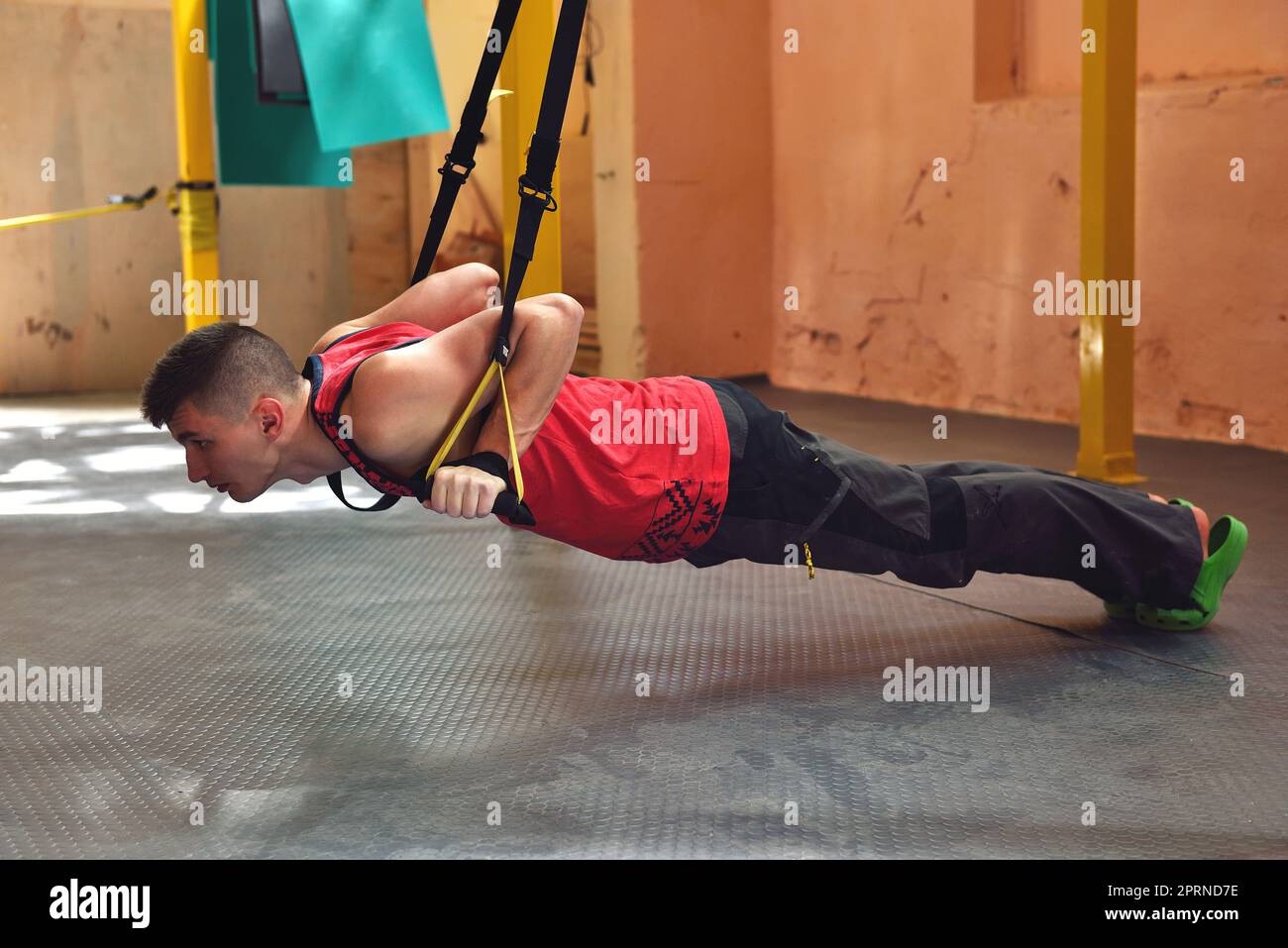 Junger Mann macht Pendeltraining mit Fitnessgurten im Fitnessstudio Stockfoto
