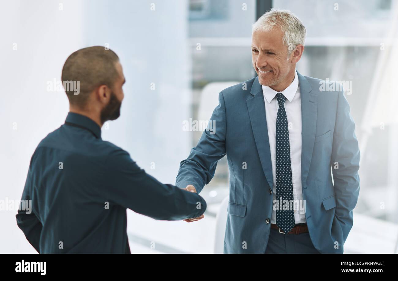 Herzlichen Glückwunsch. zwei Geschäftsleute schütteln sich im Büro die Hände. Stockfoto