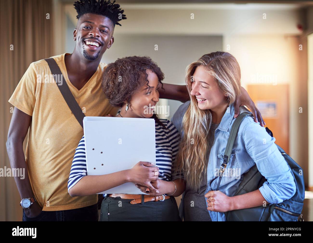 Die Freundschaften, die du im College aufbaust, gehören zu den besten. Eine Gruppe von Universitätsstudenten, die in einem Flur auf dem Campus stehen Stockfoto