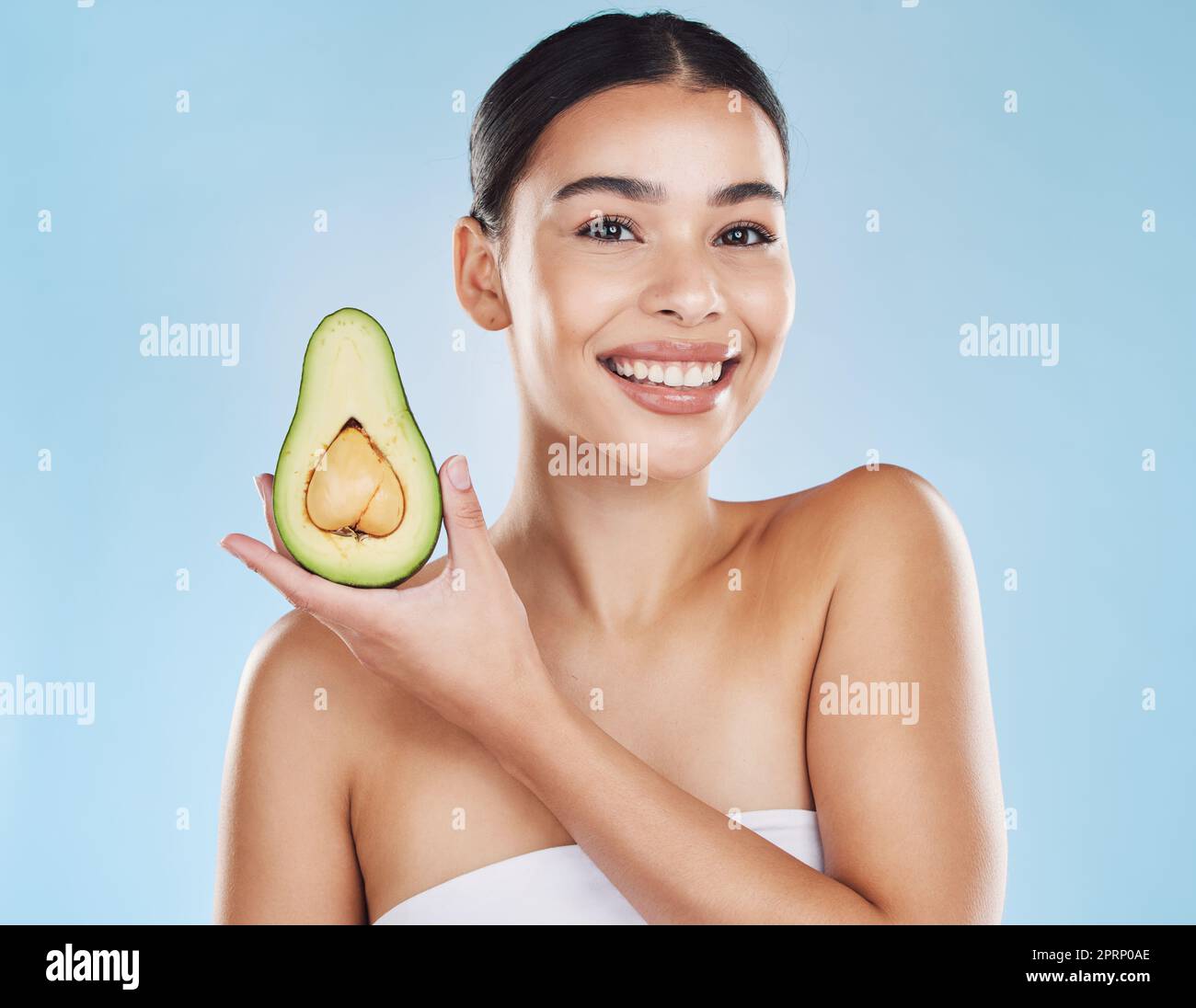Hautpflege, Gesundheit und Avocado mit einem Frauenporträt auf Studio-blauem Hintergrund und Mockup. Junges Modell mit gesunder Fruchternährung für Gesicht, Hautpflegezutaten und saubere, perfekte oder natürliche Ergebnisse Stockfoto
