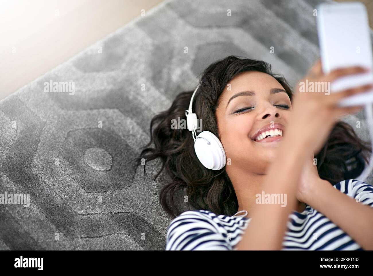 Melodische Momente. Eine junge Frau, die zu Hause Musik hört. Stockfoto