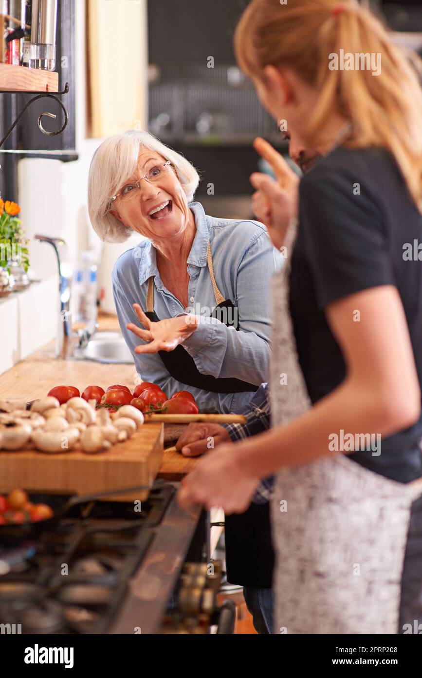 Lustige Zeiten und gutes Essen. Eine ältere Frau und eine junge Frau kochen zusammen über einem Herd. Stockfoto