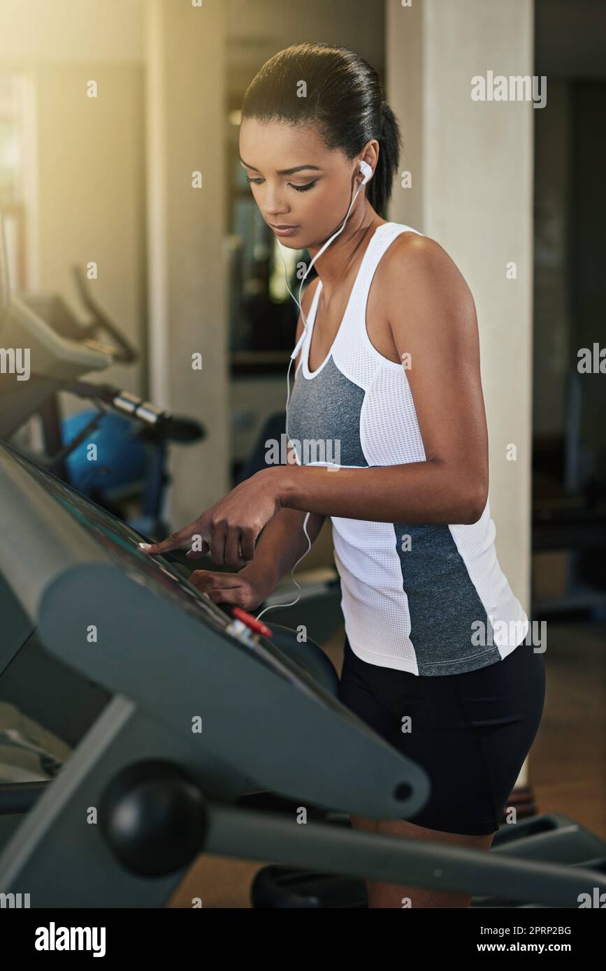 Eine junge Frau trainiert auf einem Laufband im Fitnessstudio. Stockfoto