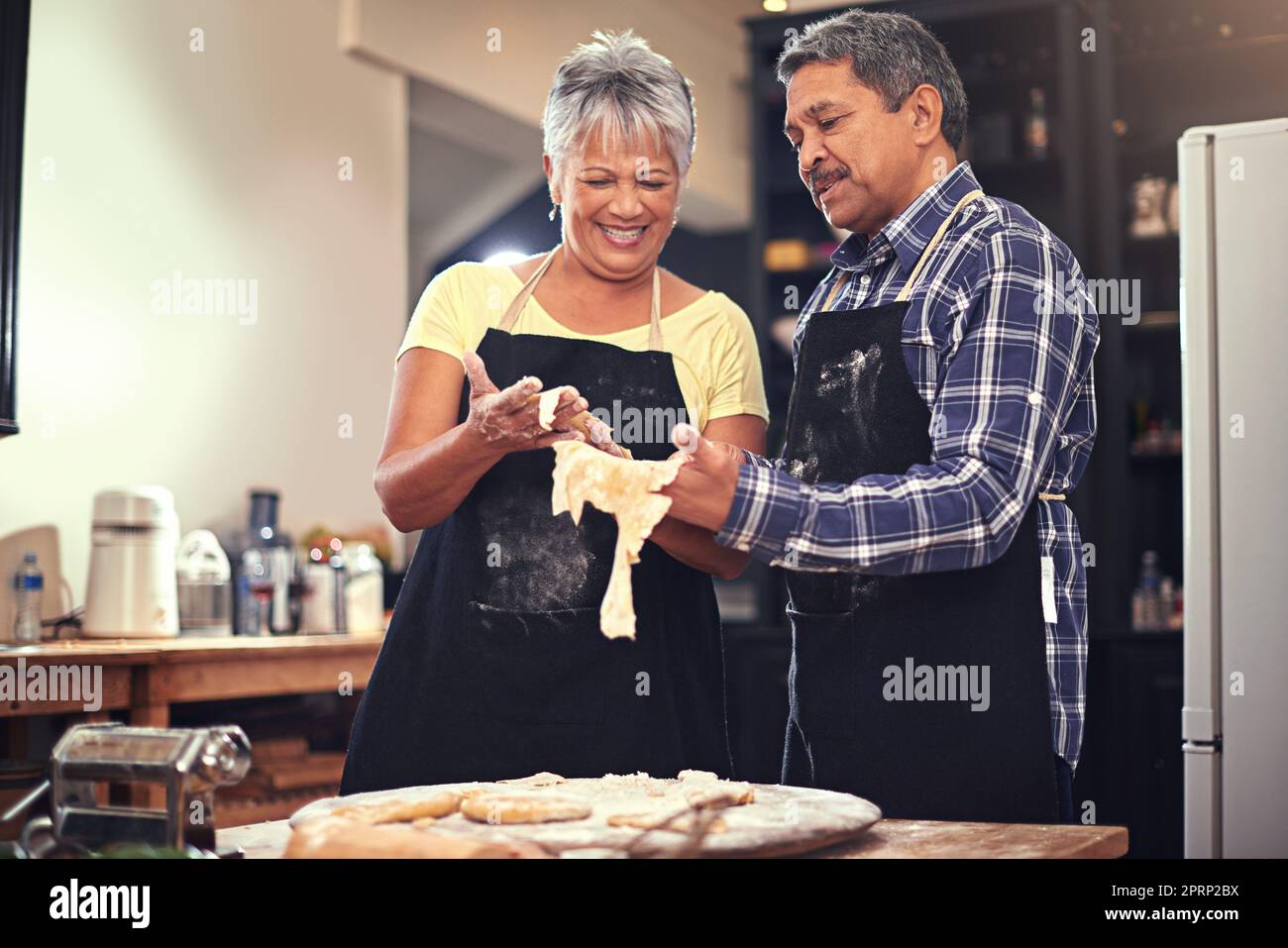 Dieser Teig ist gut zu gehen. Ein reifes Paar kocht zusammen zu Hause. Stockfoto