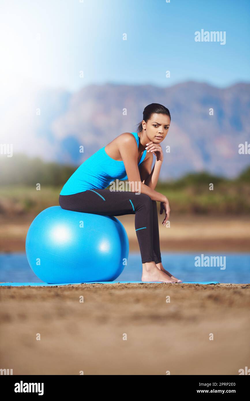 Wenn Sie abhängen können, können Sie trainieren. Eine junge Frau, die eine Pause auf ihrem Übungsball macht. Stockfoto