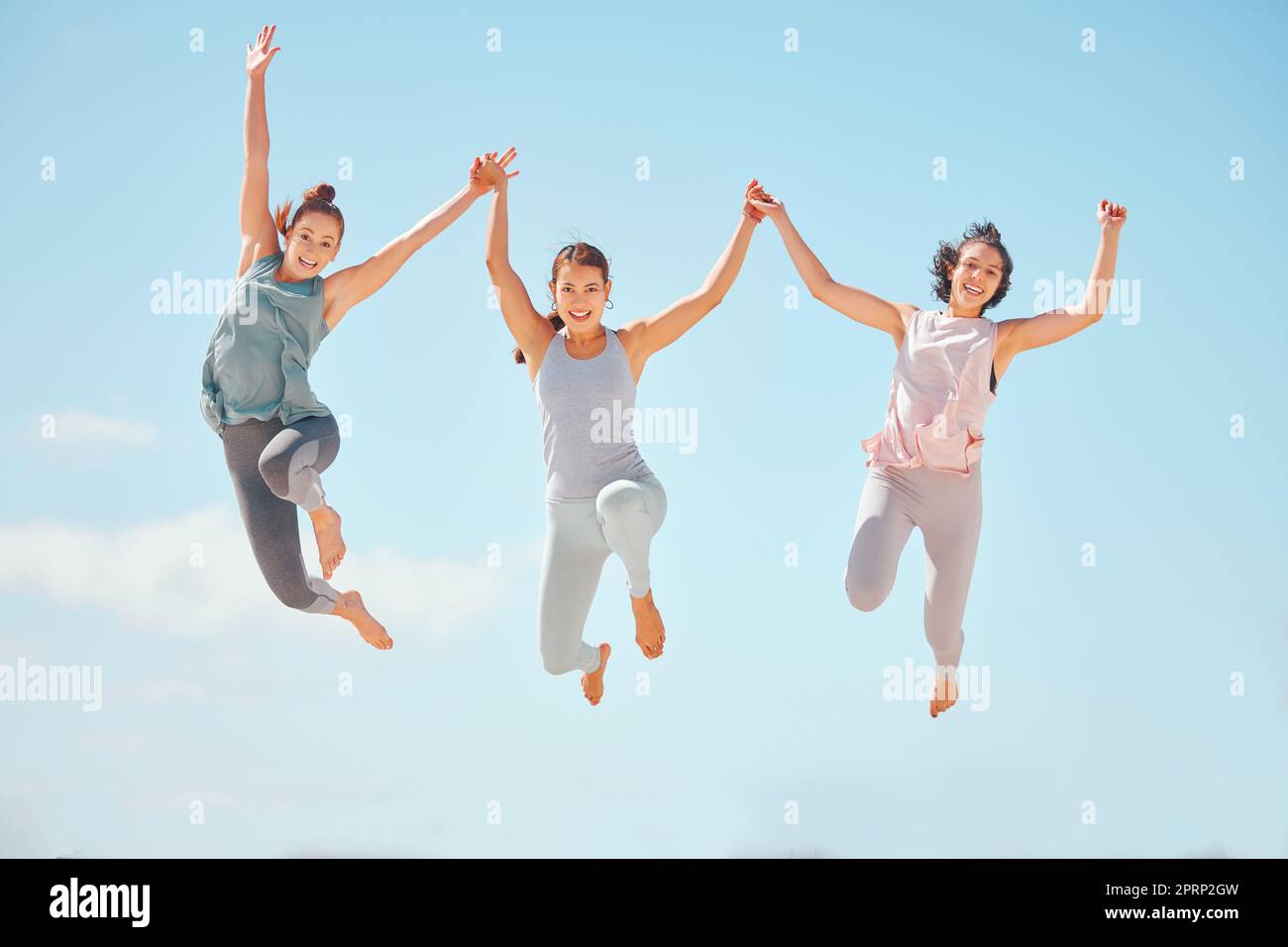 Fitness, Sportfreunde oder Frauen springen mit blauem Himmel und Hintergrund. Wellness-, Energie- und sorglose Menschen, die in ein lustiges Training springen oder im Sommer mit Sonnenschein und Mock-up im Freien trainieren Stockfoto